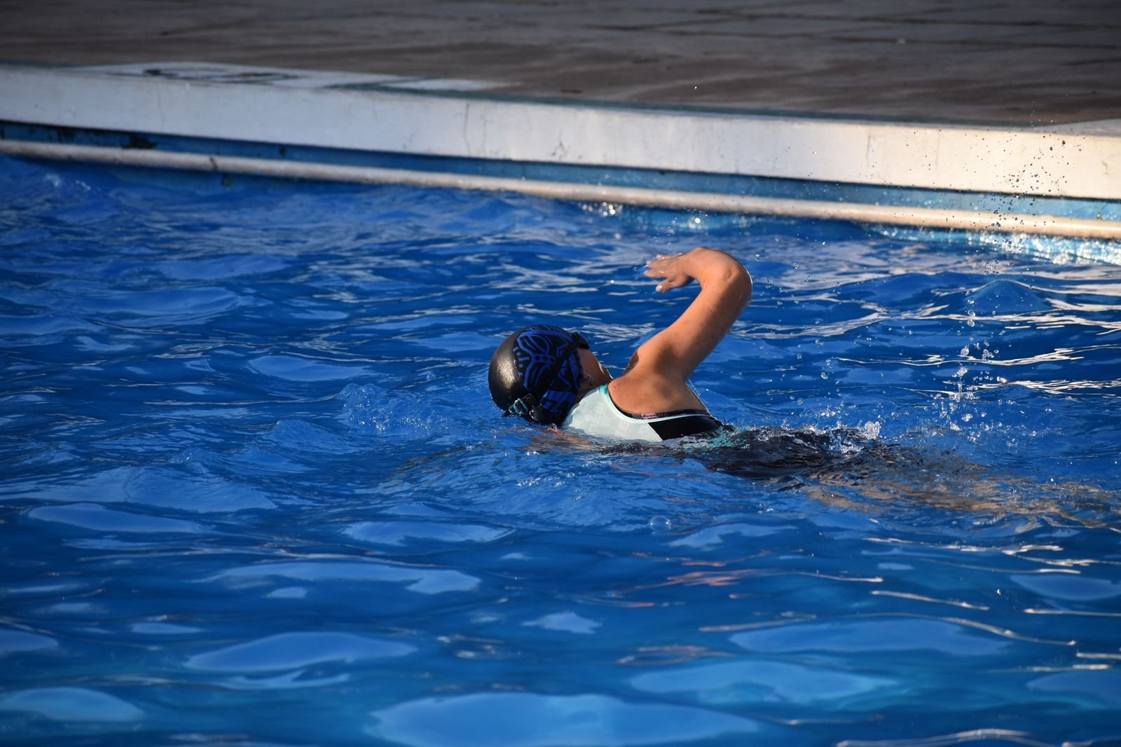 Nadadora realizando una brazada de crol en piscina